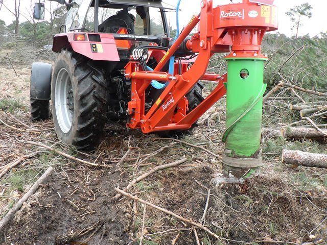 Tractor mounted stump grinder clearing stumps from a lot